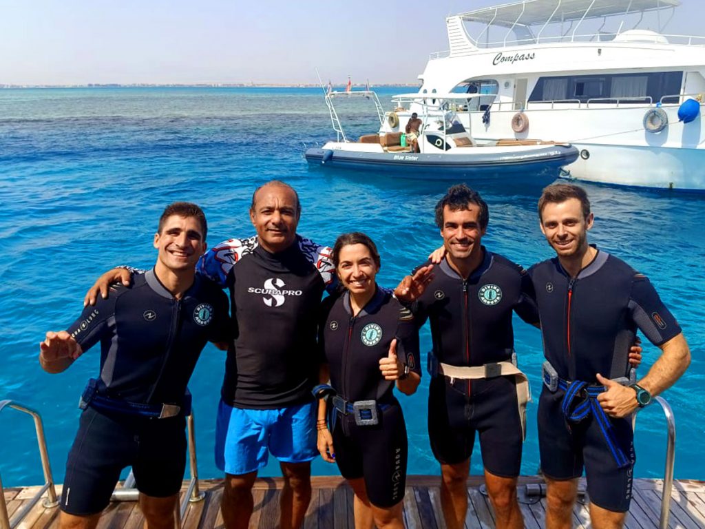 Group of new divers on a boat, smiling before their first open water dive in the Red Sea