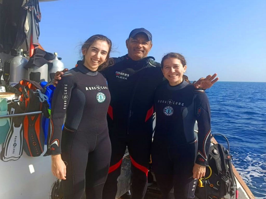 An instructor leading a small group of divers along a colorful Red Sea reef