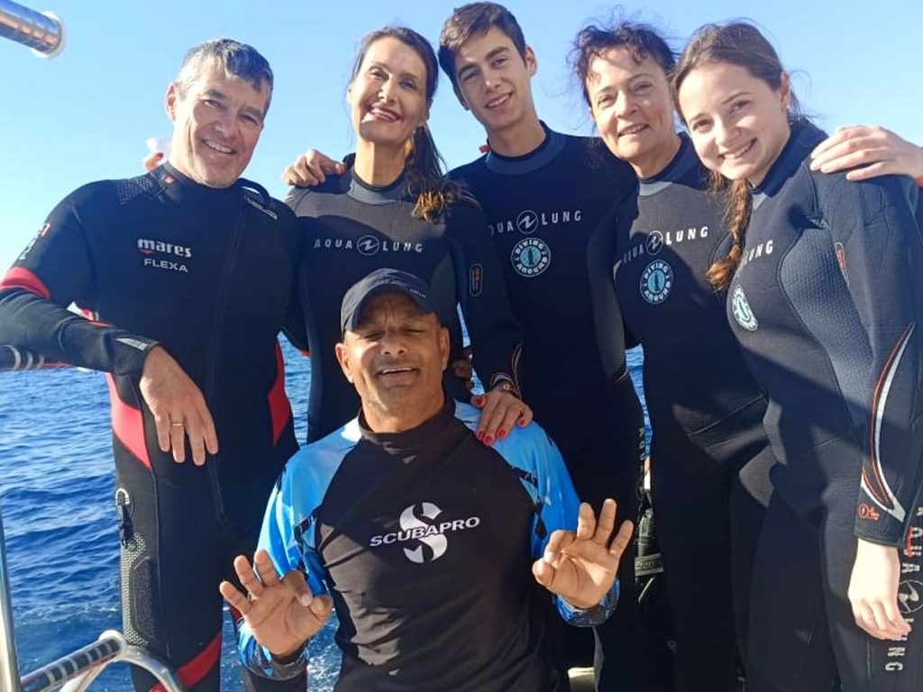Scuba diving instructor with student in clear turquoise water
