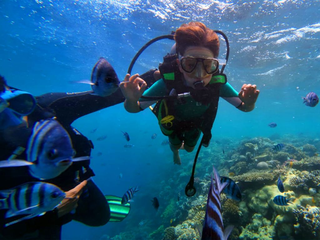 First-time scuba diver with instructor in shallow Hurghada reef