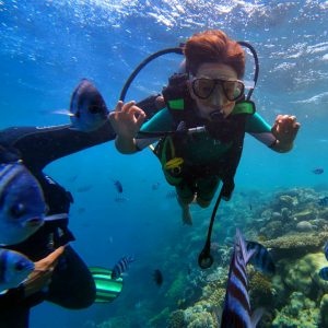 First-time scuba diver with instructor in shallow Hurghada reef