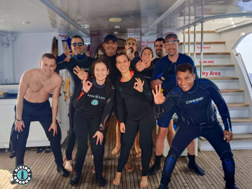 Happy diver about to backroll into the clear blue water on a daily dive trip