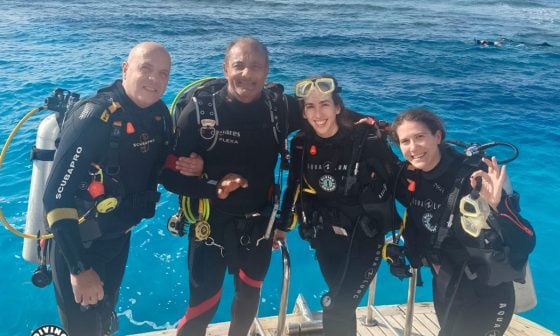 Happy diver about to backroll into the clear blue water on a daily dive trip